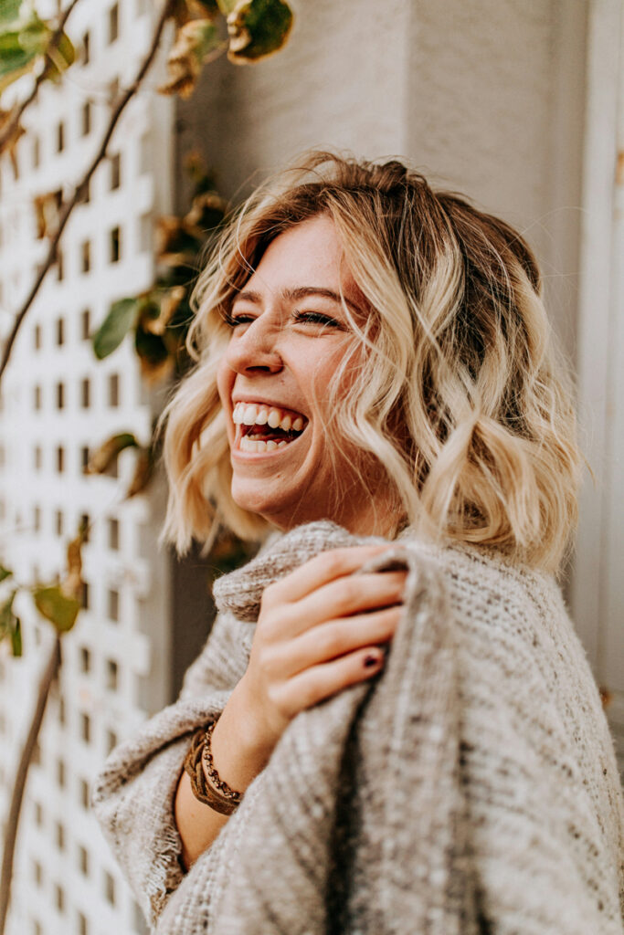 Woman smiling and feeling hopeful, symbolizing a positive start to wellness counseling at Nourish Well Counseling in Glen Ellyn, IL